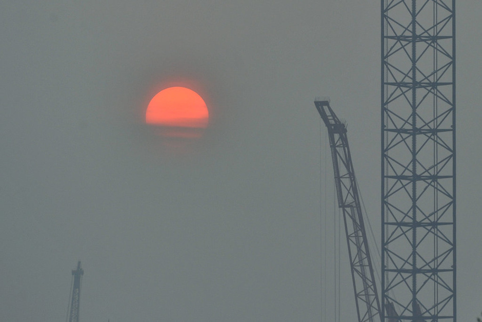 2014年10月08日,一轮初升的太阳在辽宁省大连市雾蒙蒙的天空中显得格外红。